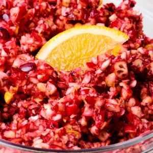Cranberry relish in a glass bowl with an orange slice for garnish.