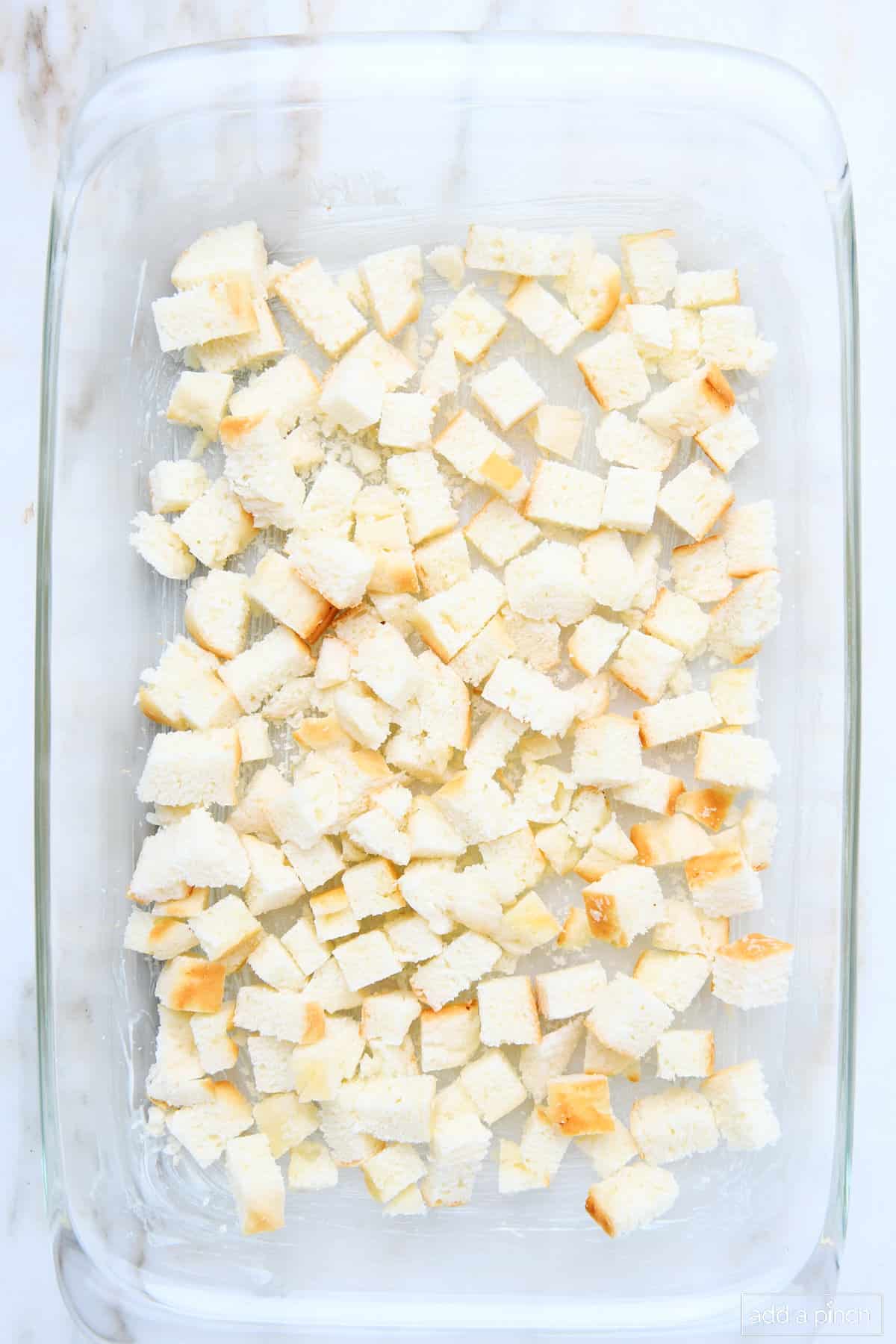 Bread cubes in a 9x13 glass baking dish.