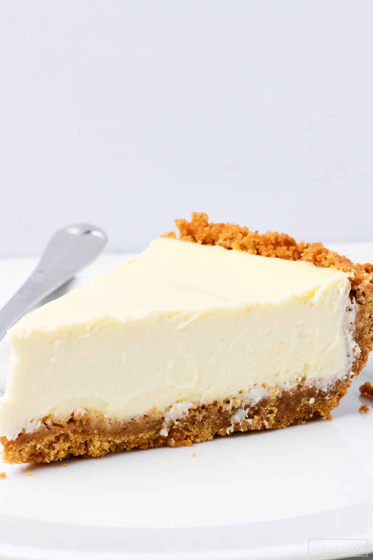 Slice of cheesecake pie on a white plate.