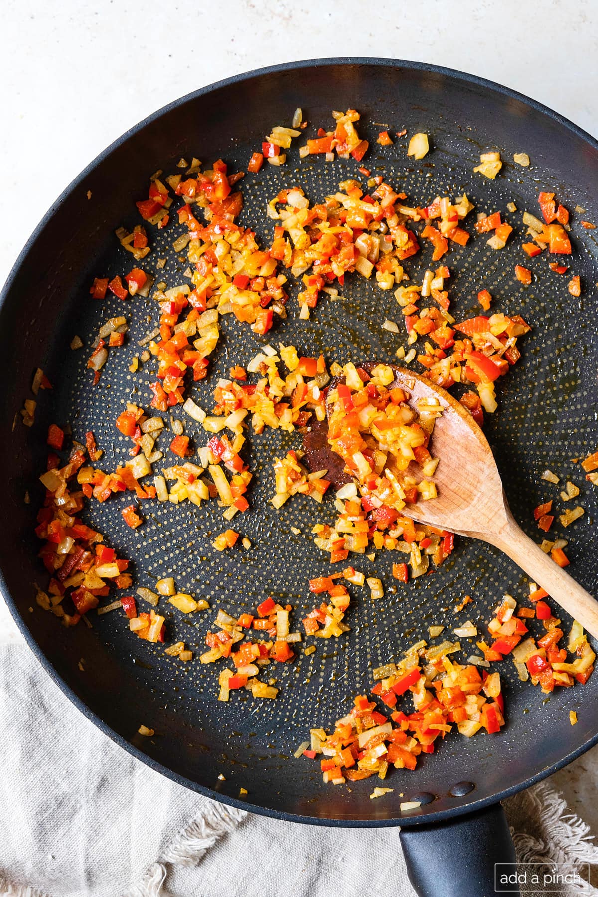 Onion and red pepper in a skillet with seasonings ready for mixing for black bean burgers.