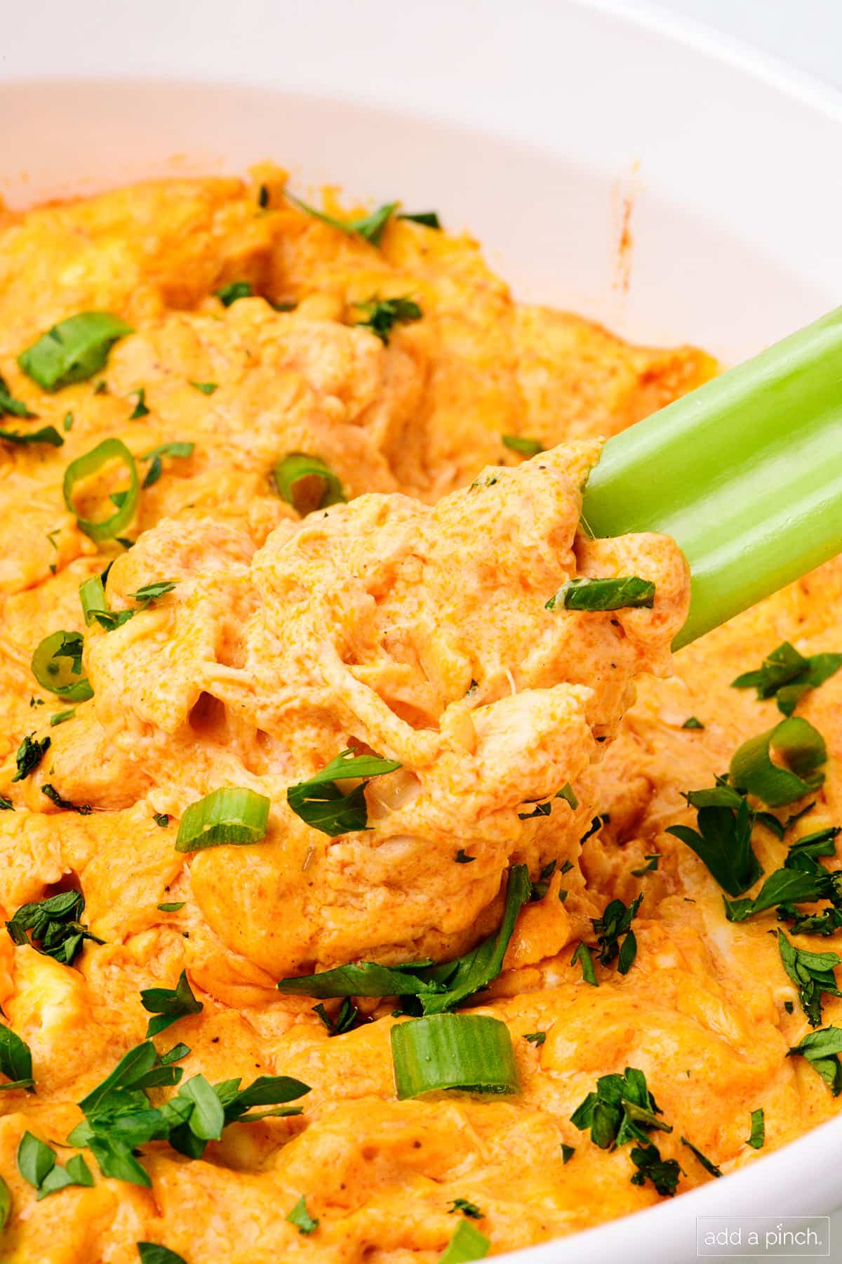 Celery stick dips up garnished buffalo chicken dip.
