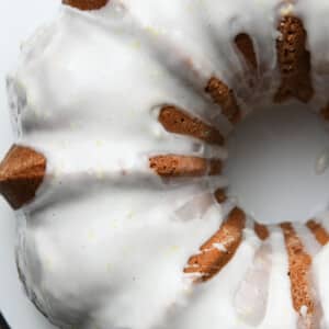 Overhead view of lemon pound cake drizzed with lemon buttermilk glaze sitting on a white plate.