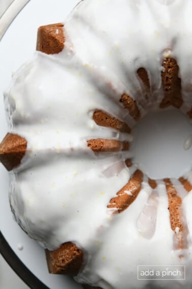 Overhead view of lemon pound cake drizzed with lemon buttermilk glaze sitting on a white plate.