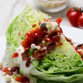 Classic wedge salad with bacon, tomatoes, homemade dressing.