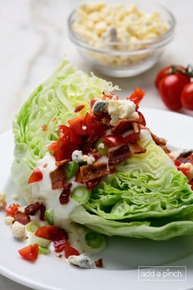 Classic wedge salad with bacon, tomatoes, homemade dressing.