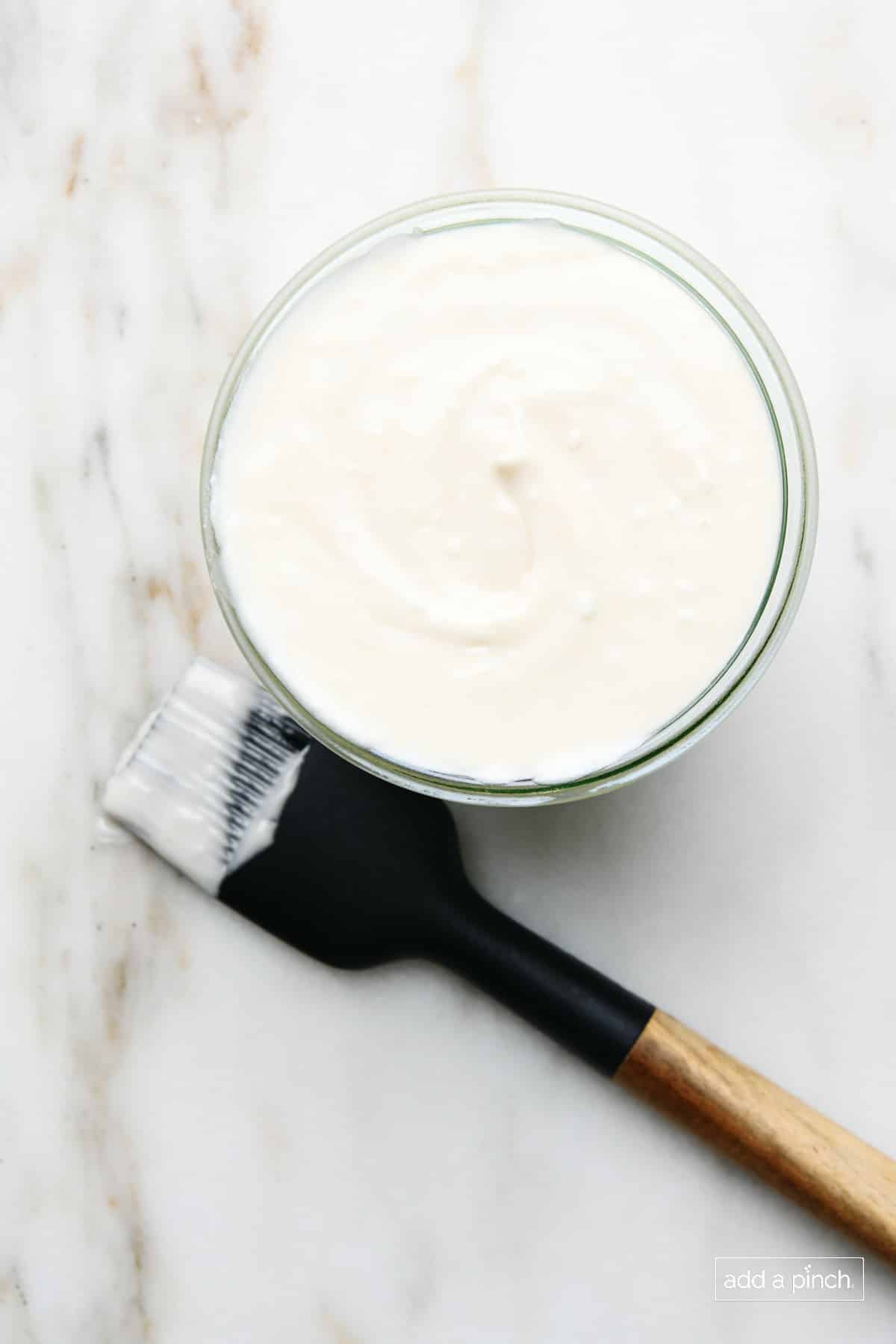 Homemade pan release in a glass jar with a pastry brush.