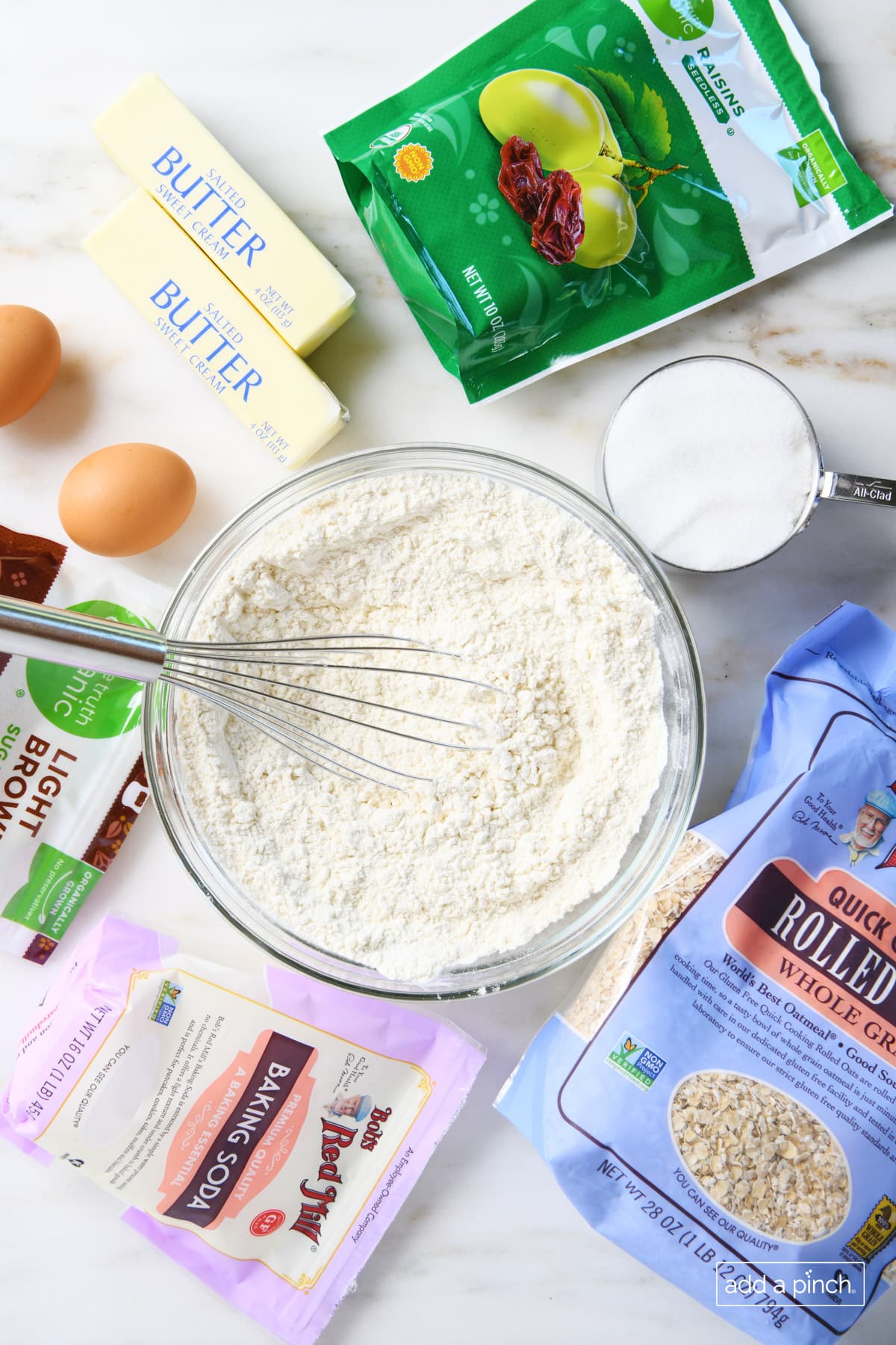 Ingredients for Oatmeal Raisin Cookies, like flour, brown and granulated sugars, butter, eggs, quick cooking rolled oats, raisins, salt and vanilla.