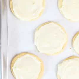 Frosted Lofthouse Cookies on a parchment lined baking sheet.