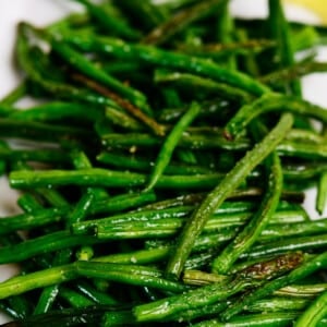 Roasted green beans with lemon wedges.