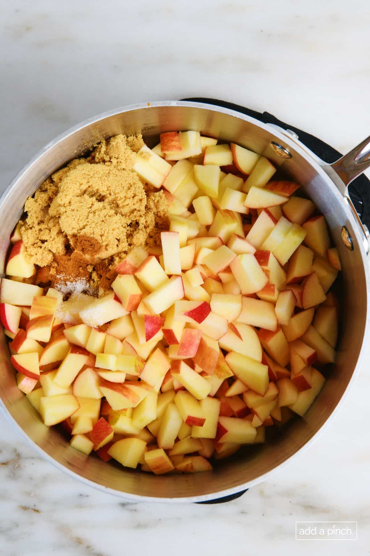 Apples, butter, flour, ground cinnamon, and brown sugar in a sauce pan to make apple filling.