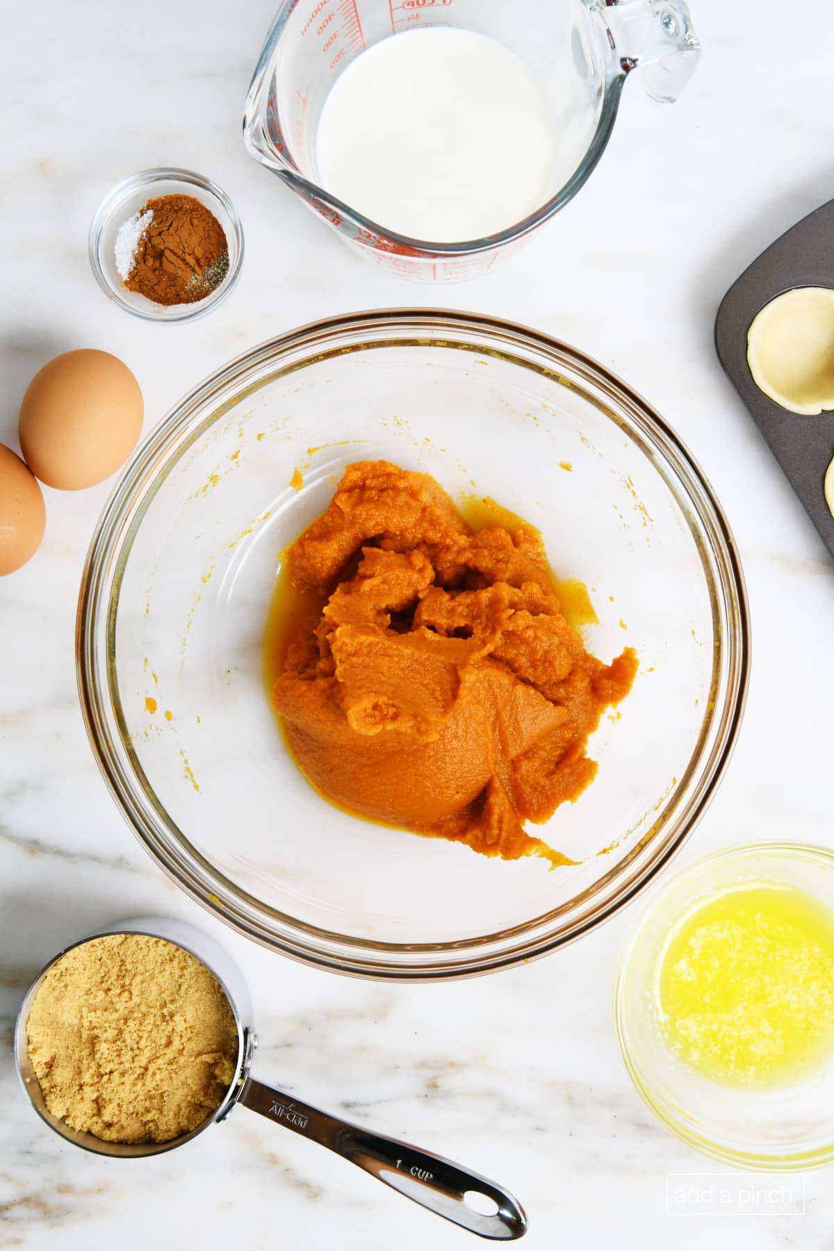 Ingredients for pumpkin pie on a marble counter.