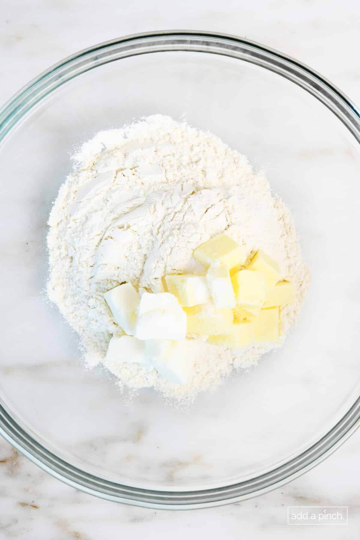 Glass bowl with cold butter and shortening cut into cubes, with flour and salt, to make pie crust.