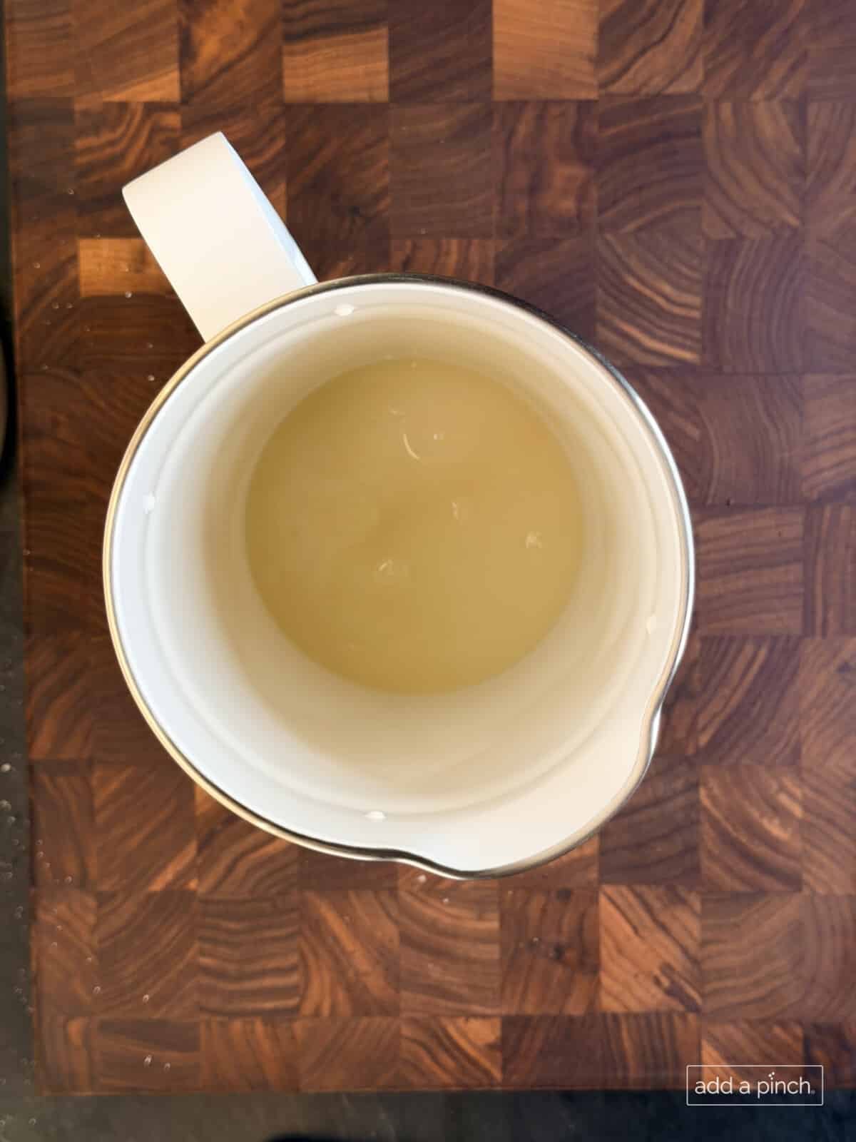 Hot water added to the sugar in pitcher for lemonade.