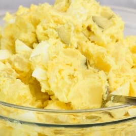 Closeup of a bowl of Southern potato salad in a glass bowl.