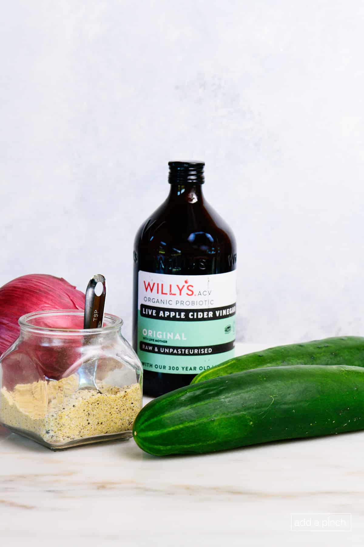 Cucumber, Stone House Seasoning, Apple Cider Vinegar, and Onion on a Marble counter.
