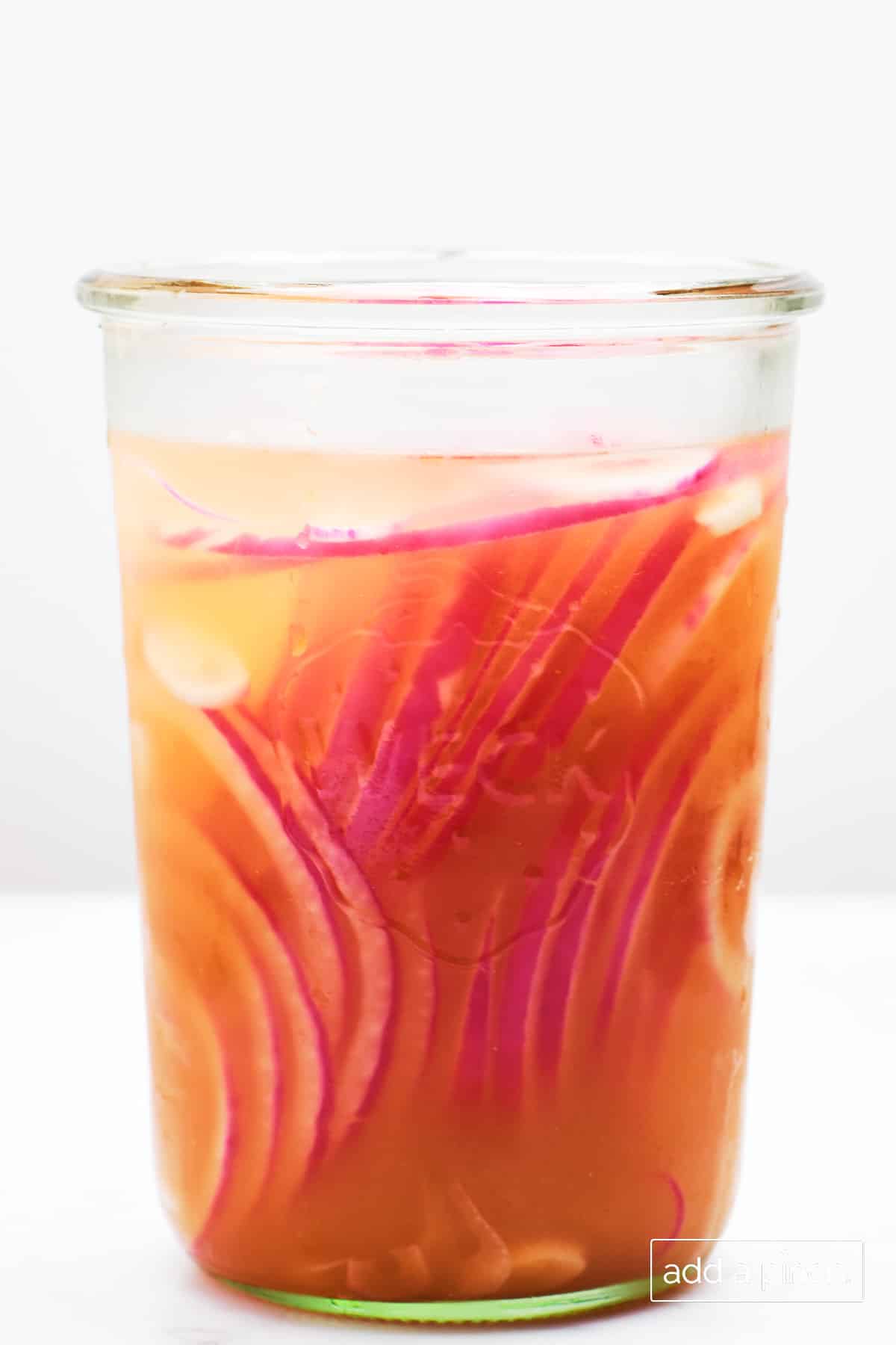 Pickled red onions in a glass jar.