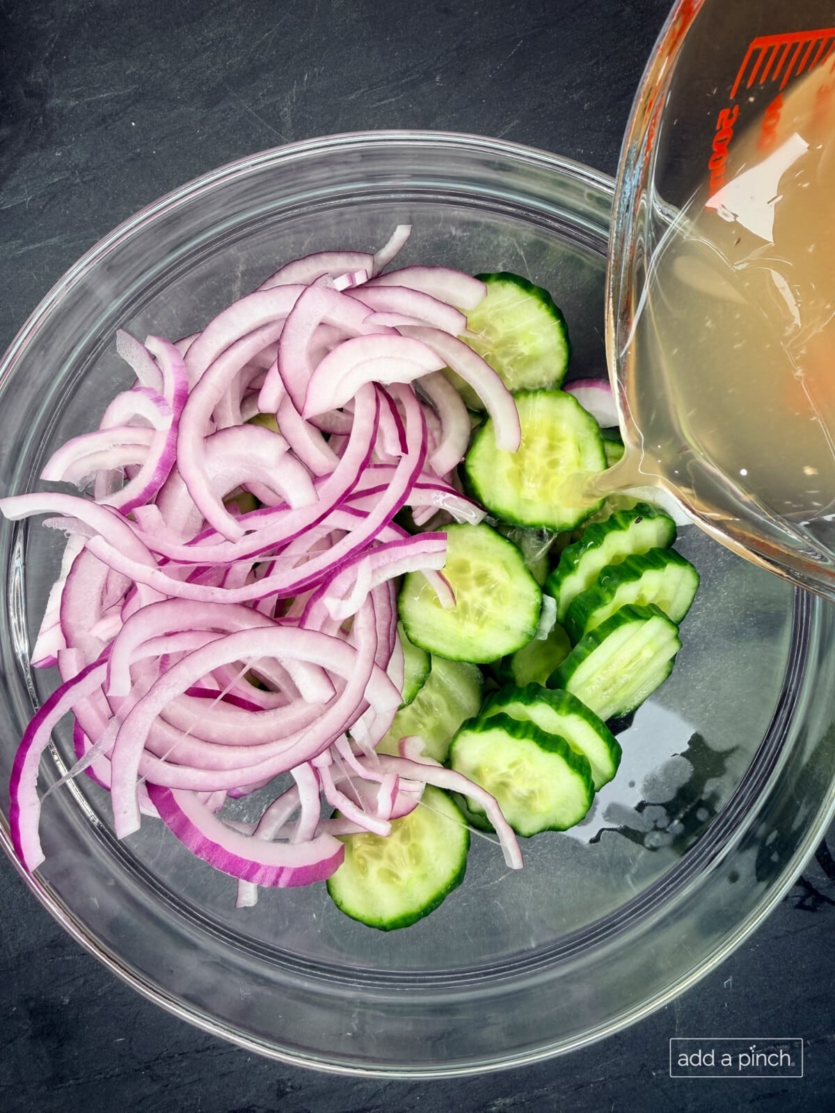 Add the dressing: Pour the dressing over the prepared cucumbers and onion.