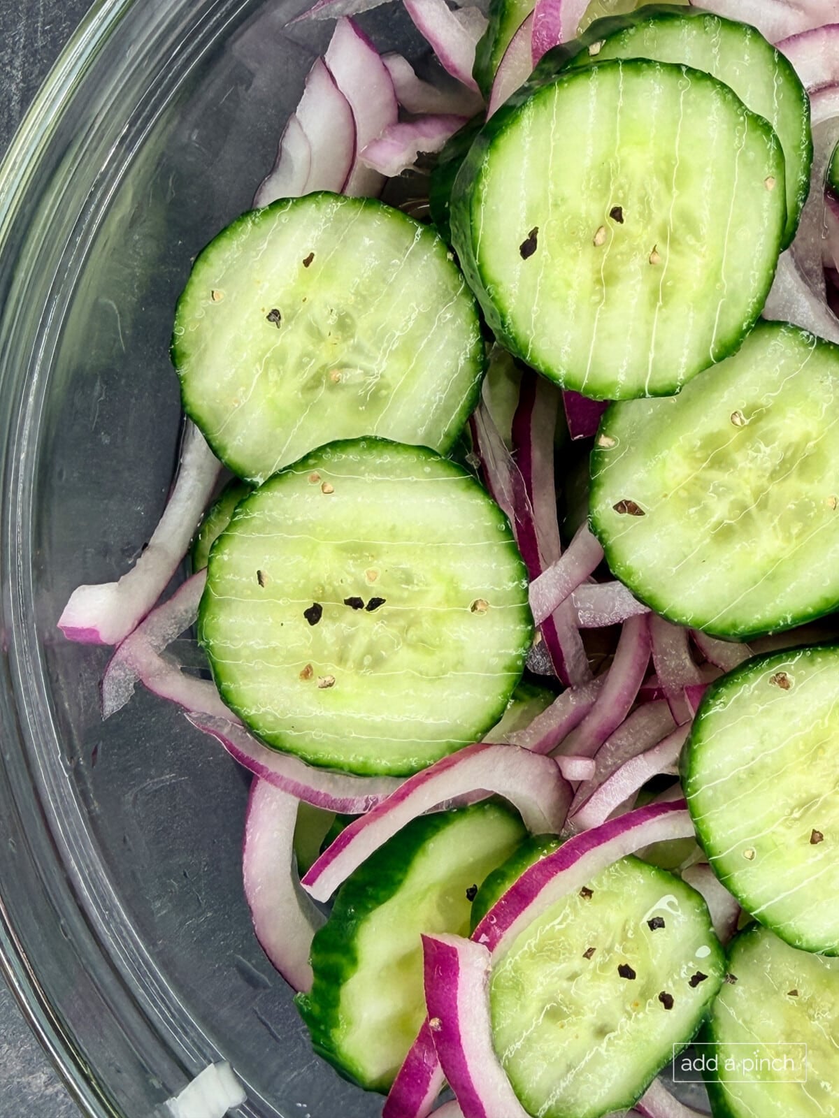 Cucumber onion salad recipe served in glass bowl, perfect refreshing side dish for BBQs and potlucks