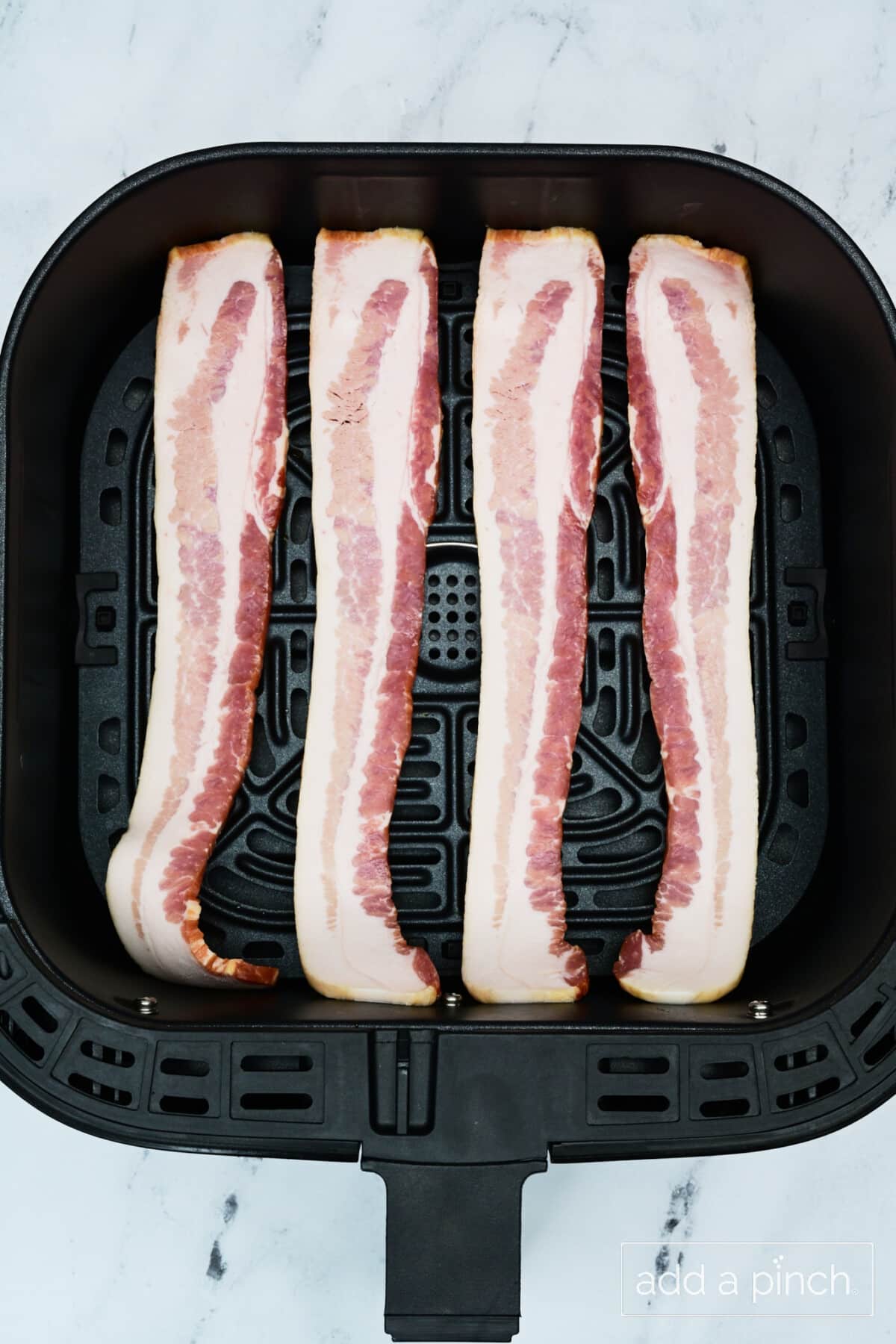 Bacon in air fryer basket.
