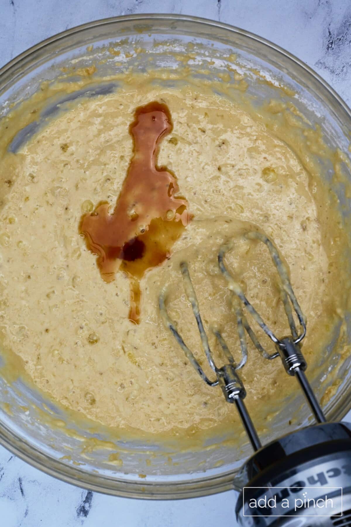 Vanilla extract is added and mixed into banana bread batter.