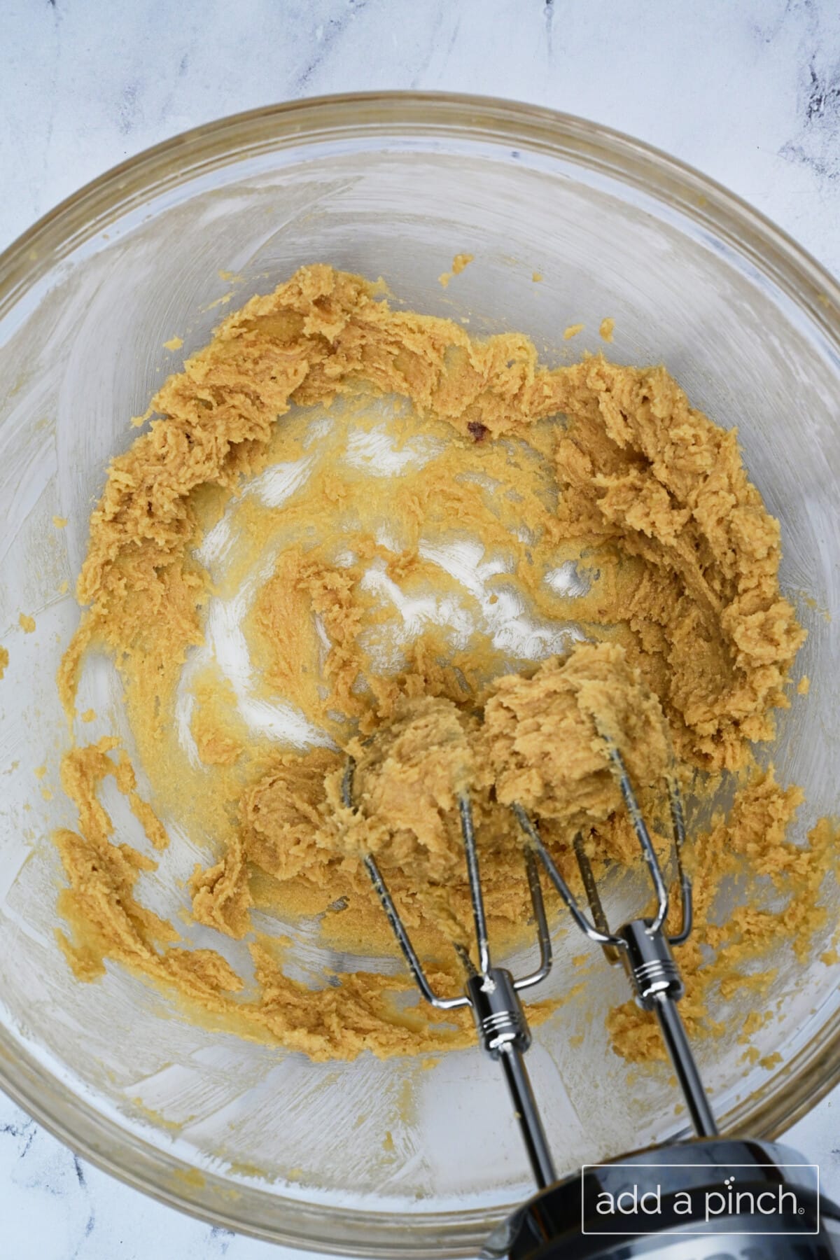 Hand mixer creaming together the softened butter and brown sugar.