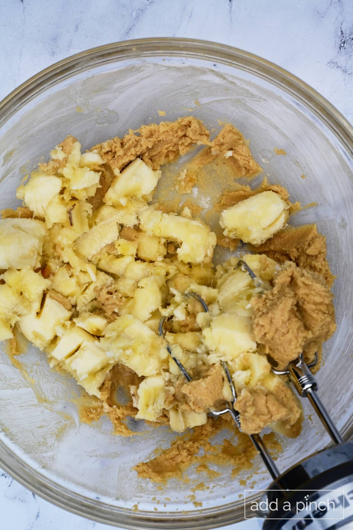 Ripe bananas are mashed and blended with the wet ingredients.