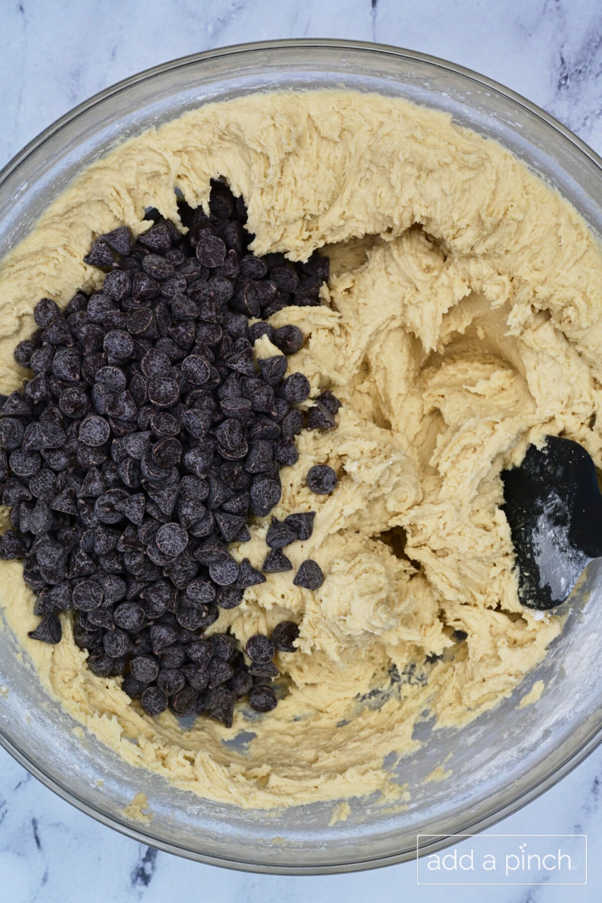 Chocolate chips are folded into cookie batter. 