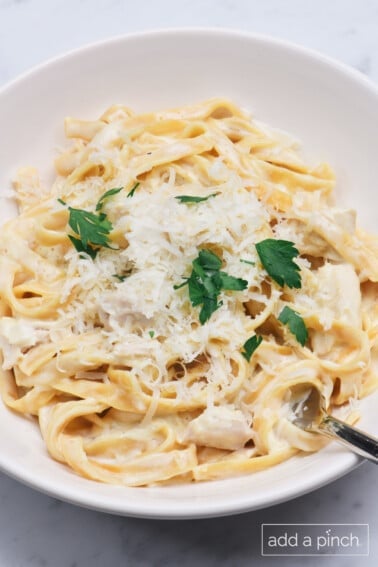 Bowl of chicken Alfredo in a creamy Alfredo sauce with parmesan cheese and parsley.