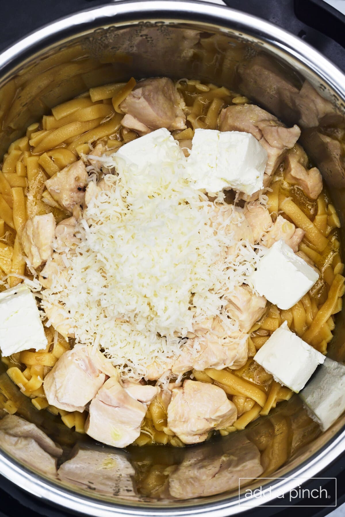 Cream and cheeses added to the Instant Pot once the noodles and chicken have cooked.