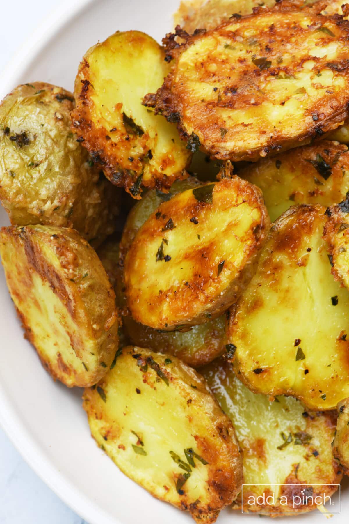 Crispy parmesan potatoes in a white serving bowl.
