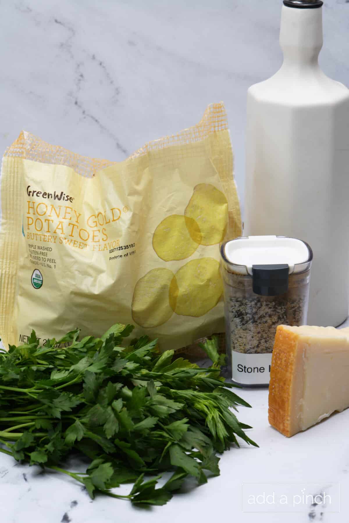 Ingredients used to make parmesan potatoes: potatoes, olive oil, seasoning, parmesan, and fresh herbs.