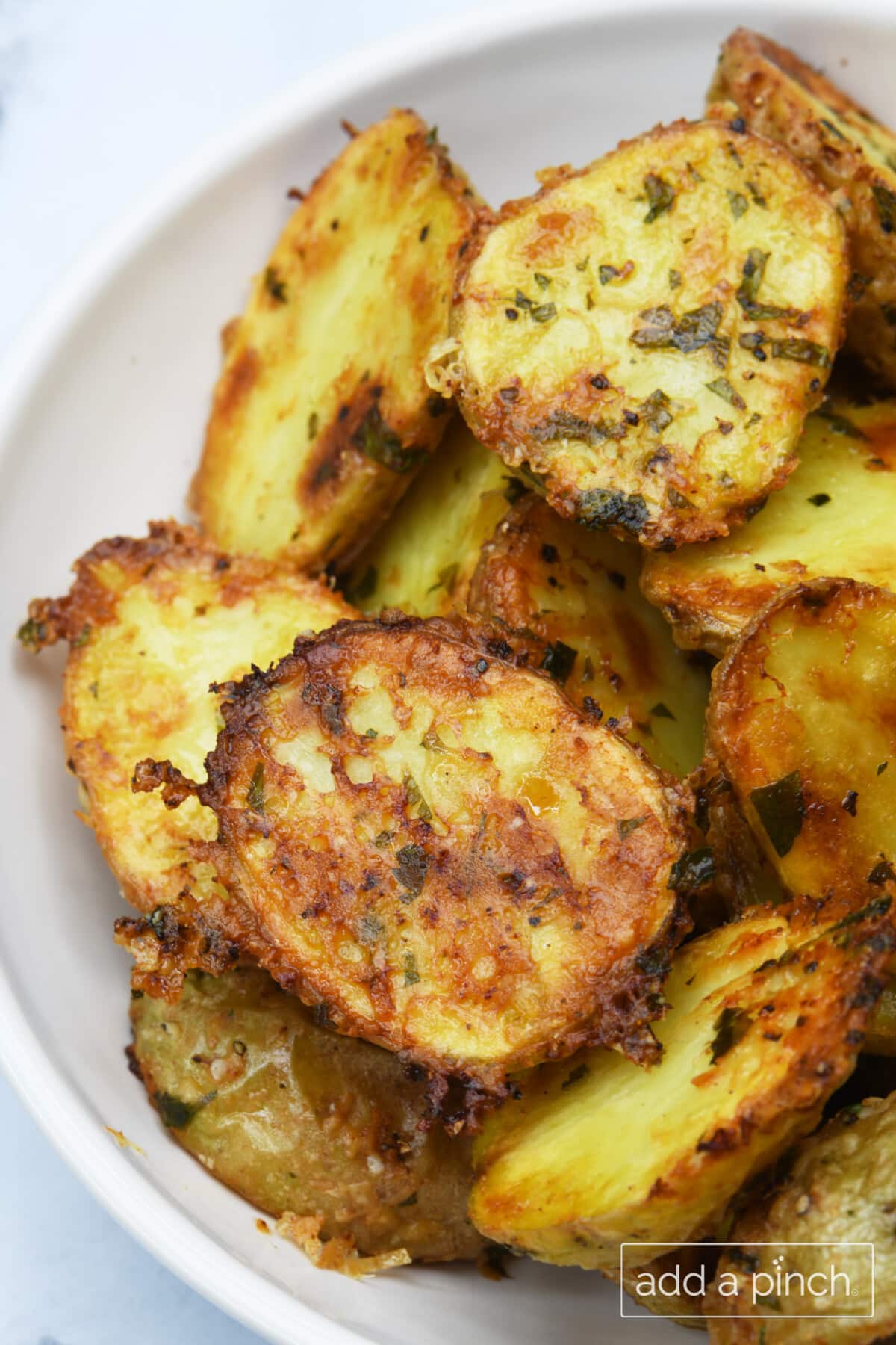 Crispy Parmesan Potatoes in a white serving bowl.