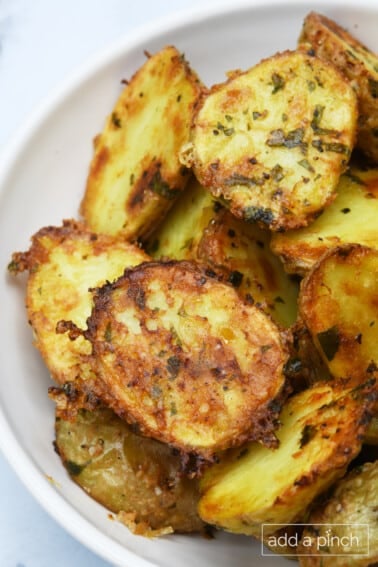 Crispy Parmesan Potatoes in a white serving bowl.