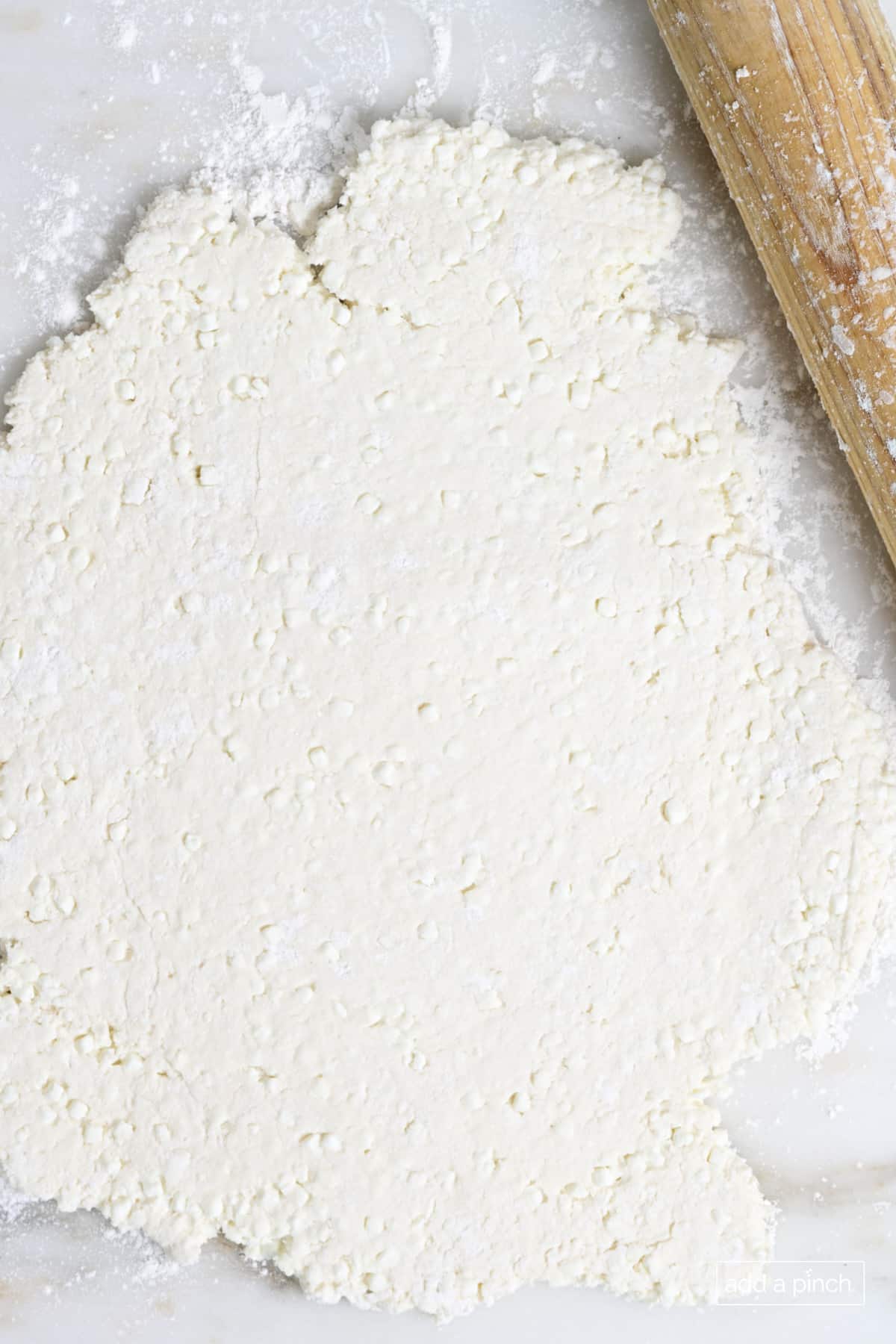 Rolled homemade pizza dough on counter.