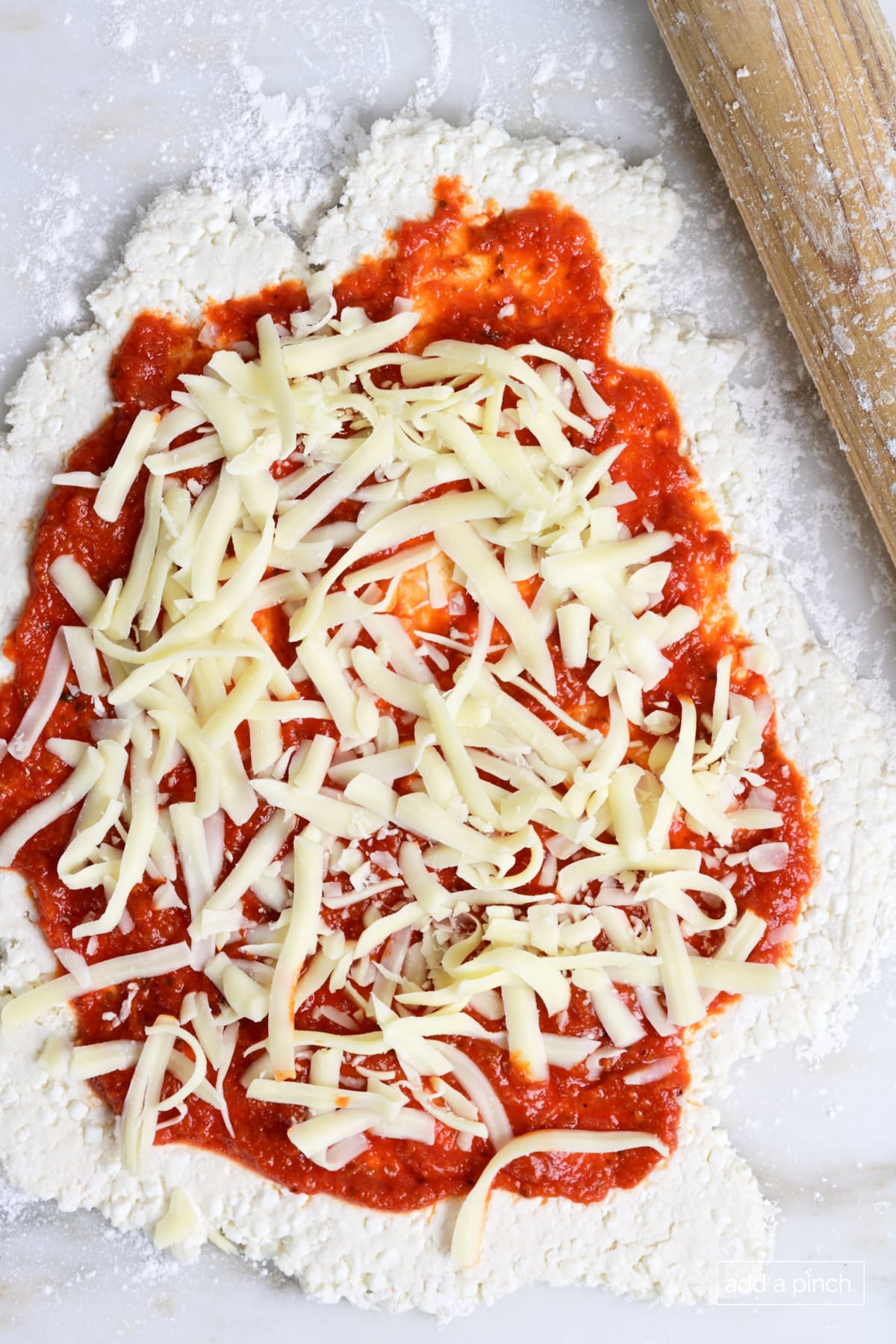 Pizza dough with mozzarella cheese.