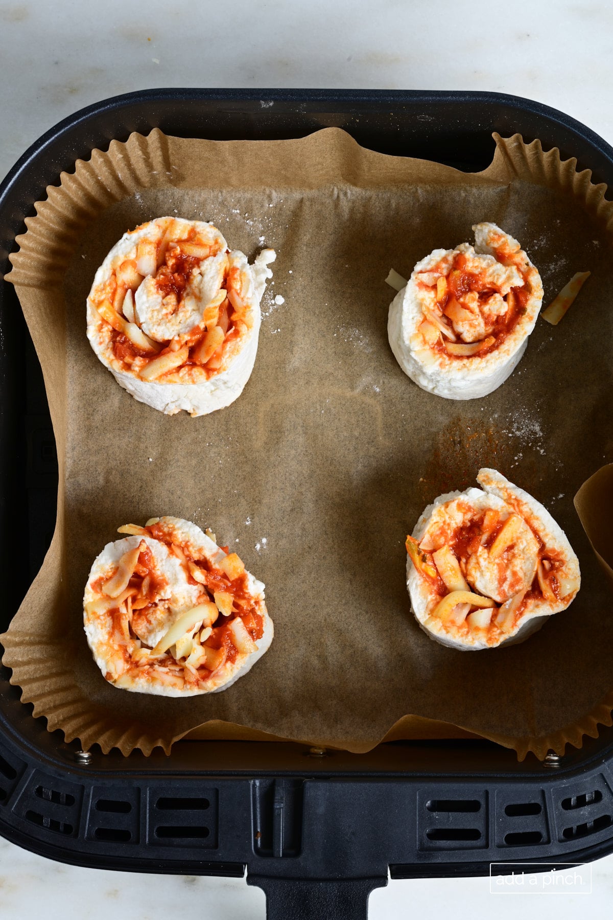 Pizza rolls in air fryer ready to cook.