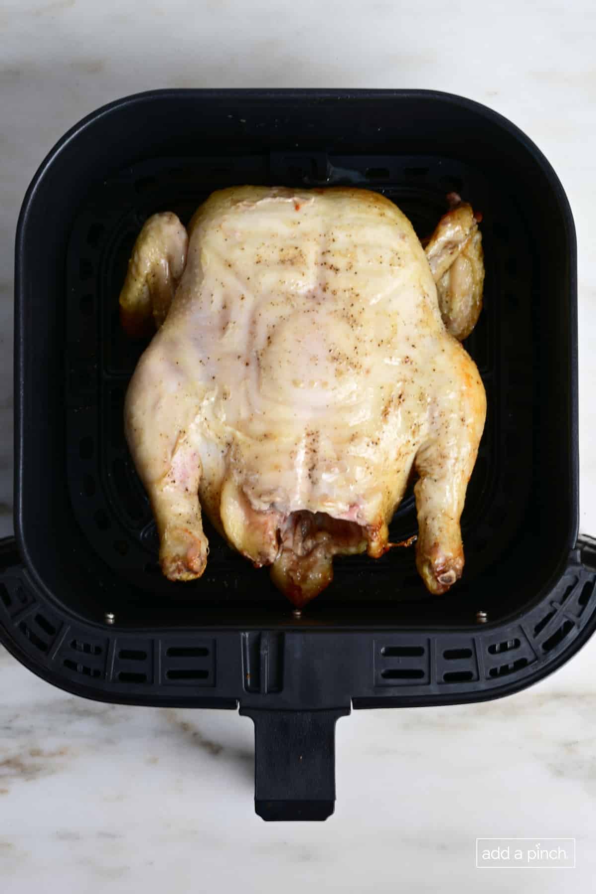 Whole chicken breast side up to complete air frying.