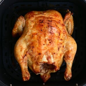 Air Fryer whole chicken in an air fryer basket.