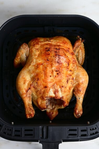 Air Fryer whole chicken in an air fryer basket.