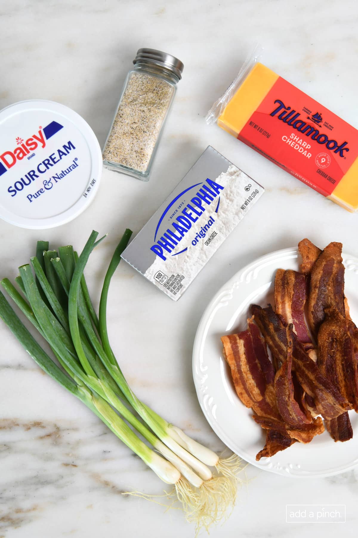 Bacon cheddar dip ingredients on a marble surface.