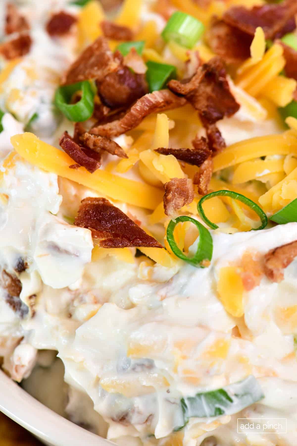 Bacon cheddar dip, also known as Neiman Marcus Dip, in a white bowl.