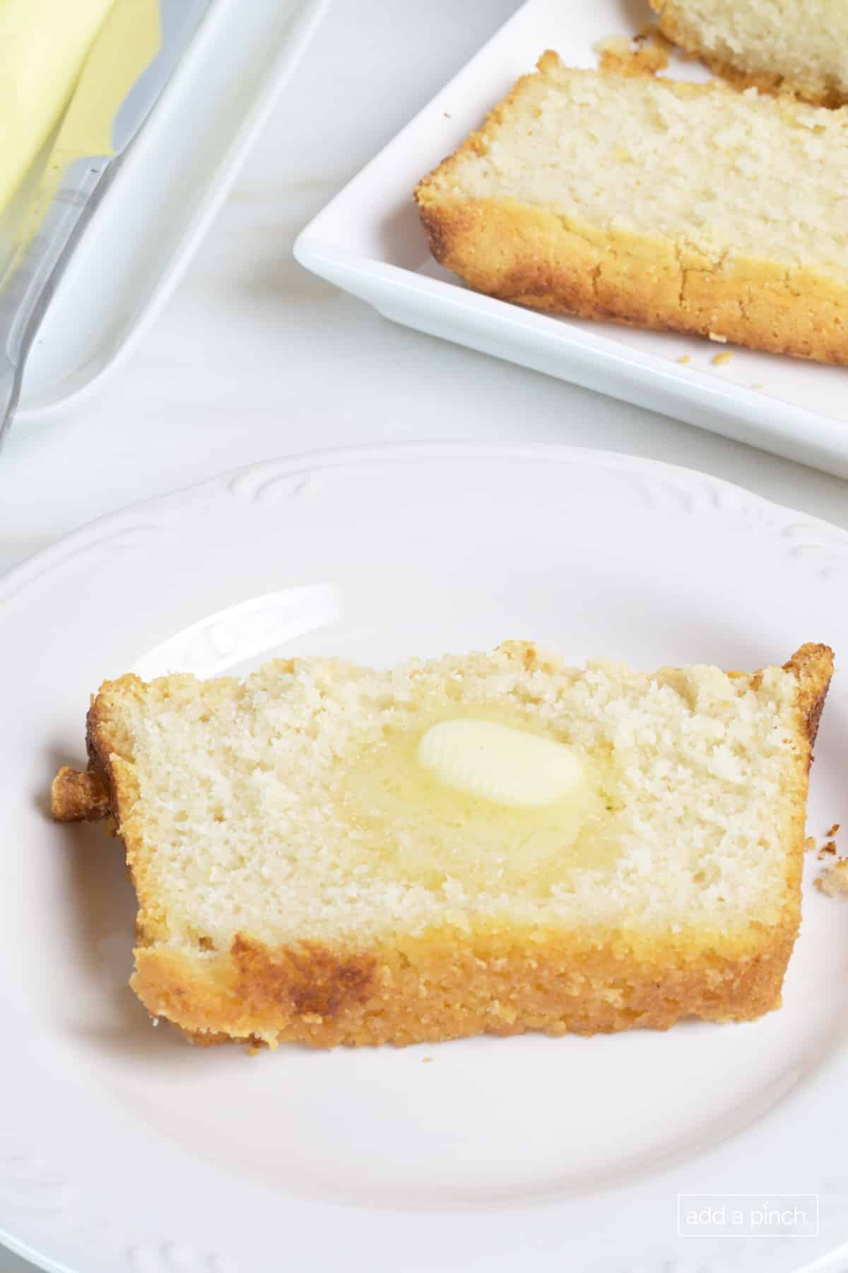 Slice of beer bread with a pat of butter.