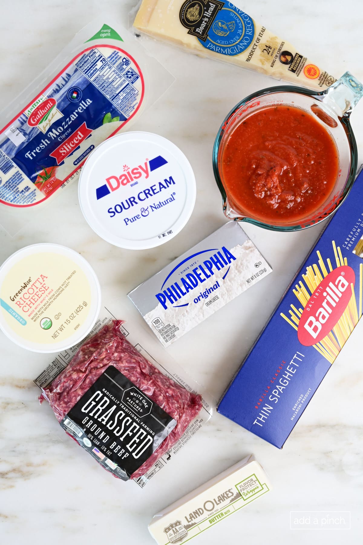 Ingredients for baked spaghetti casserole recipe  on a marble surface.
