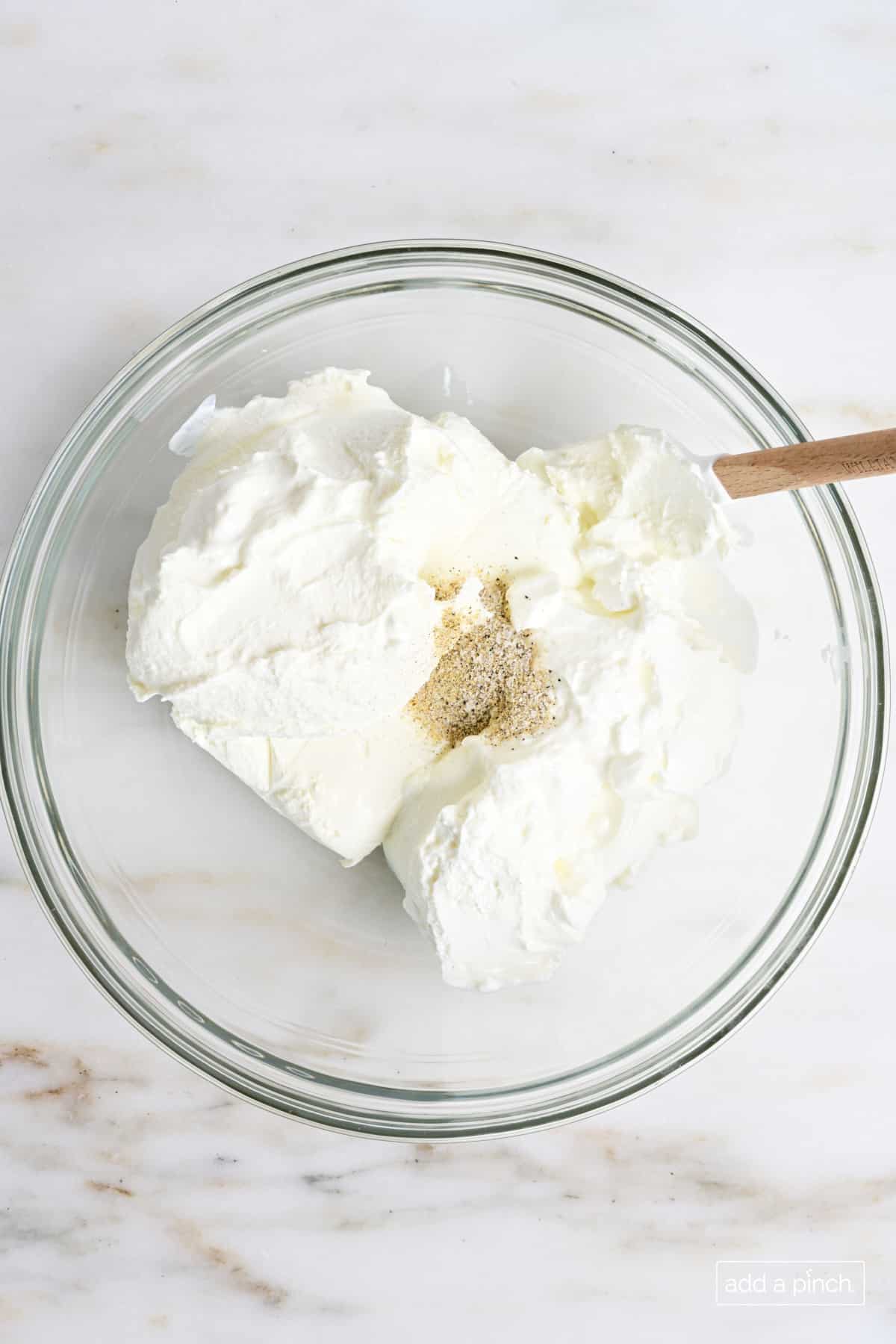 Cheese mixture in a glass mixing bowl.