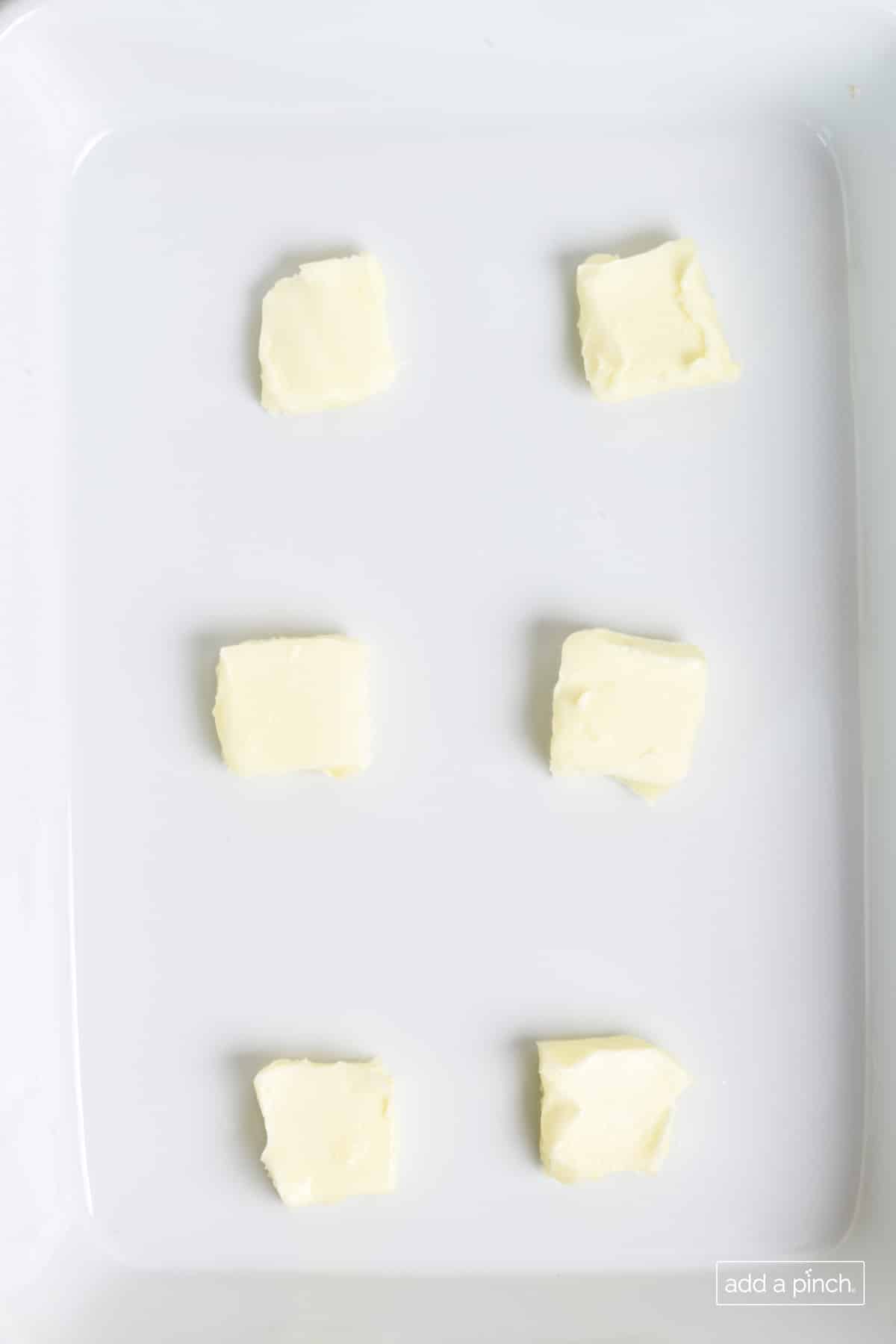 Butter in a baking dish.
