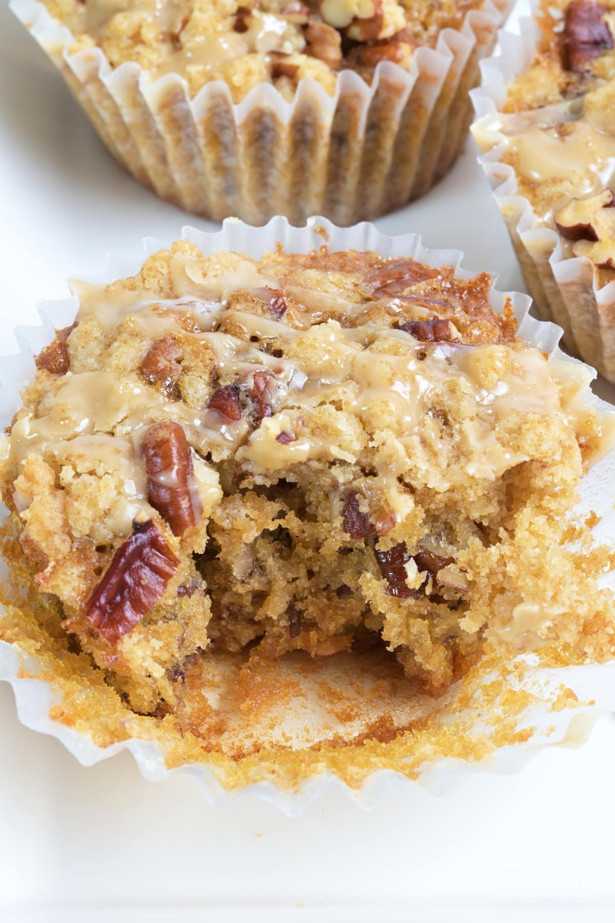 Pecan pie muffin with streusel topping and maple glaze in a cupcake liner.