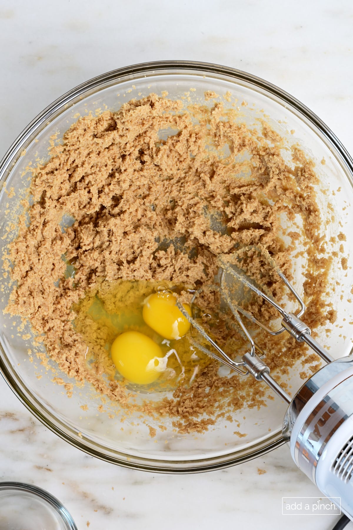 Eggs added to brown sugar and butter in mixing bowl.