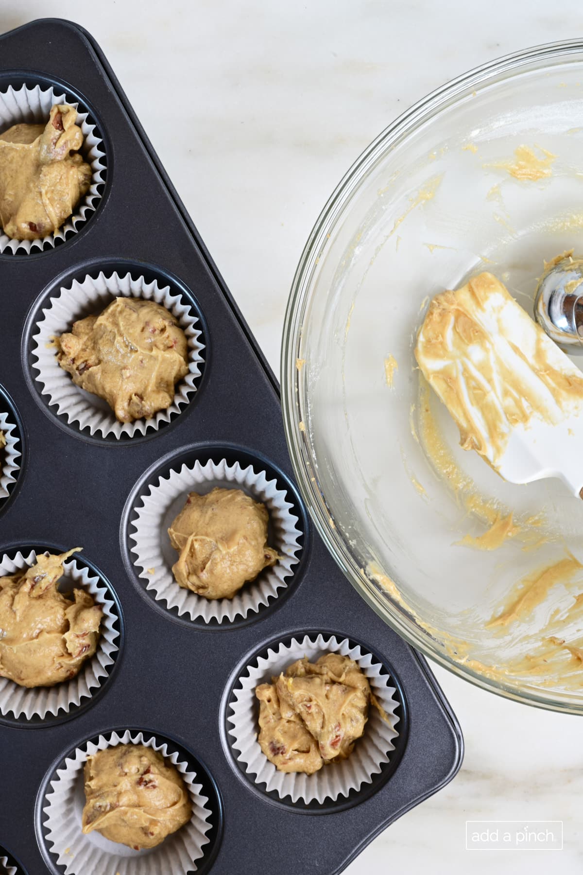 Pecan pie muffin batter in muffin pan.