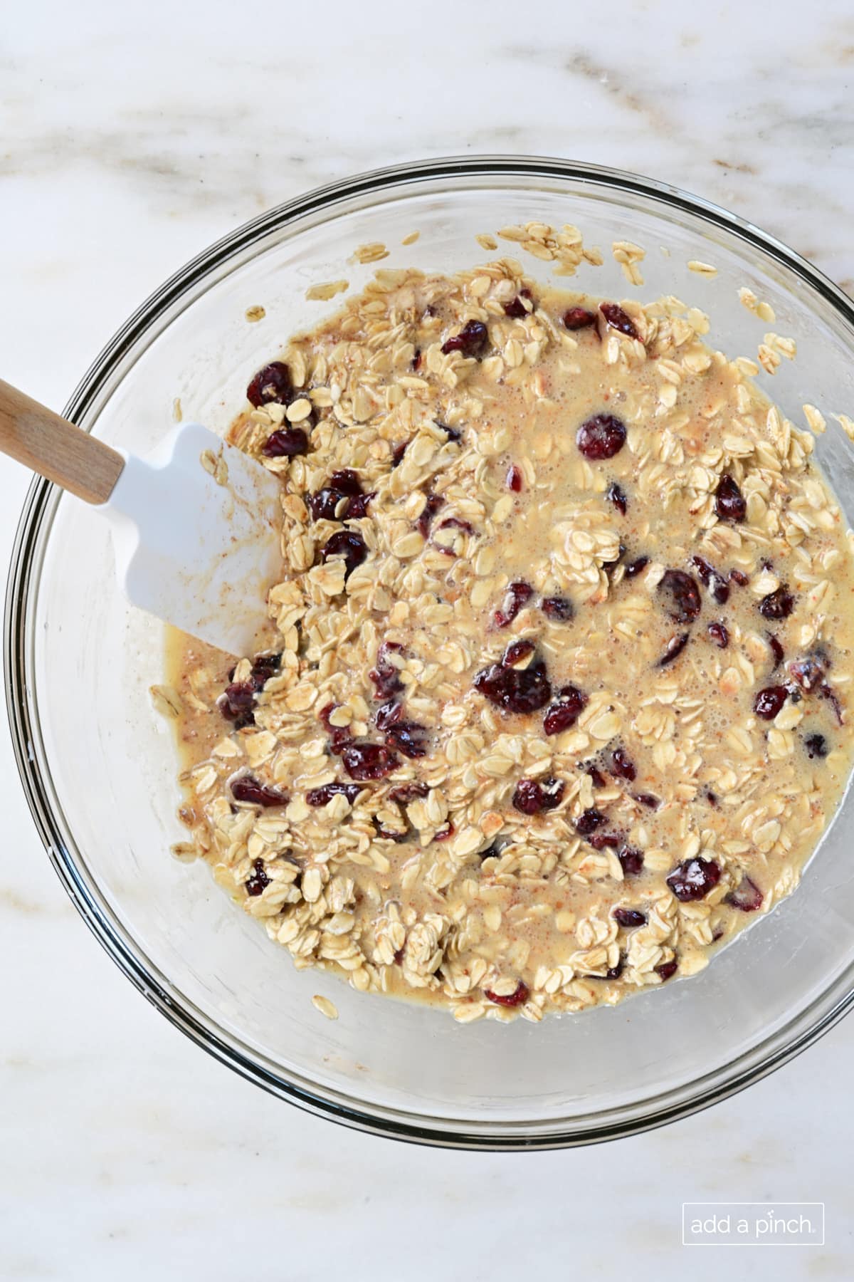 Mixed baked oatmeal batter in a glass mixing bowl.