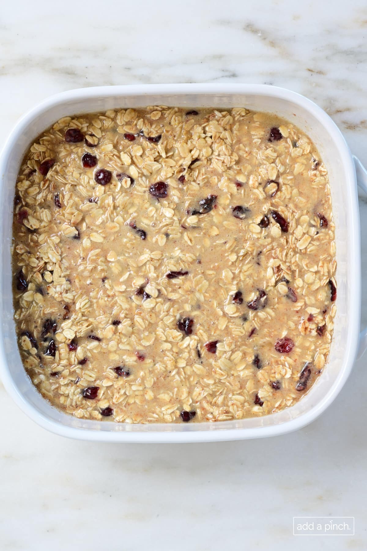 Baked oatmeal batter in a 9x9 baking pan ready to bake.